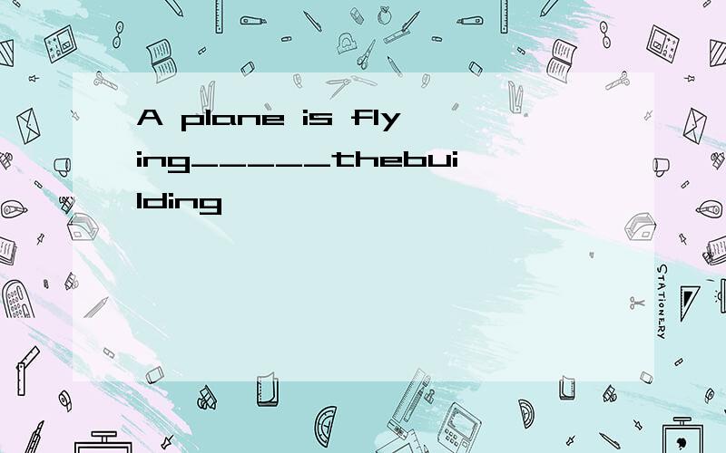 A plane is flying_____thebuilding